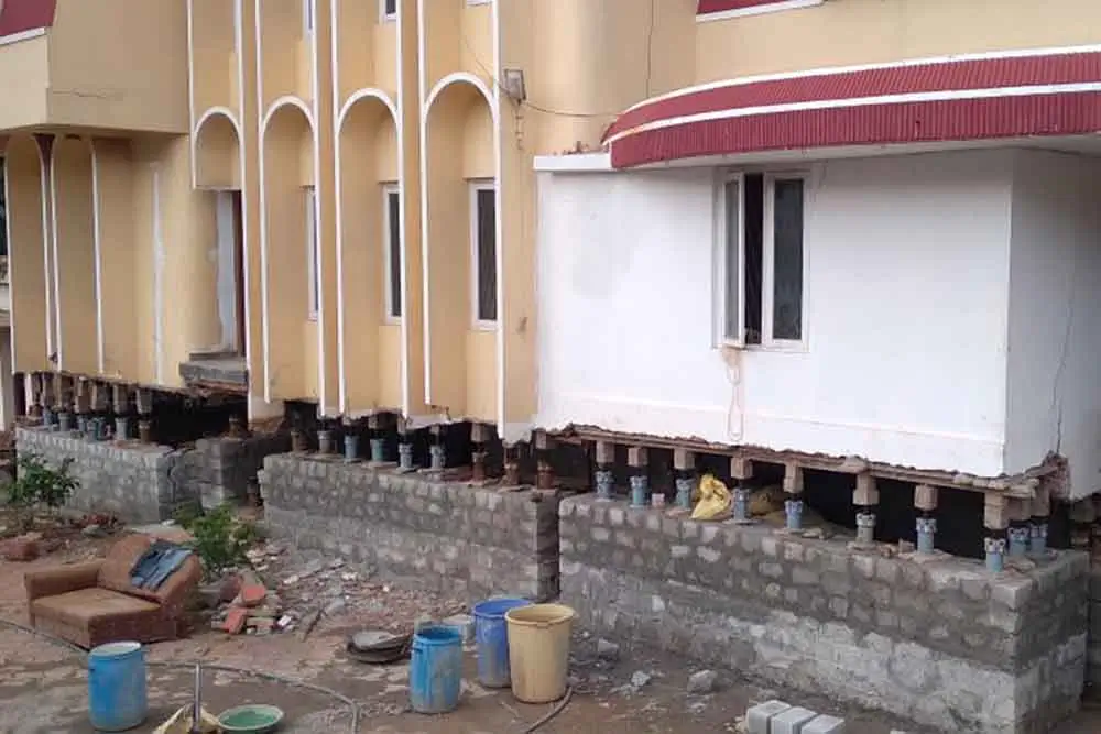 House lifting service by SRBL using hydraulic jacks to elevate a residential structure with columns, balcony, and windows – ensuring structural safety and elevation in Uttarakhand.