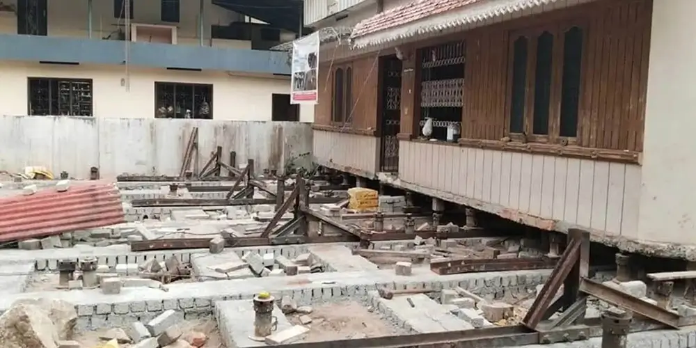 SRBL house shifting process on-site with concrete structures, windows, and debris management in earthquake-affected areas