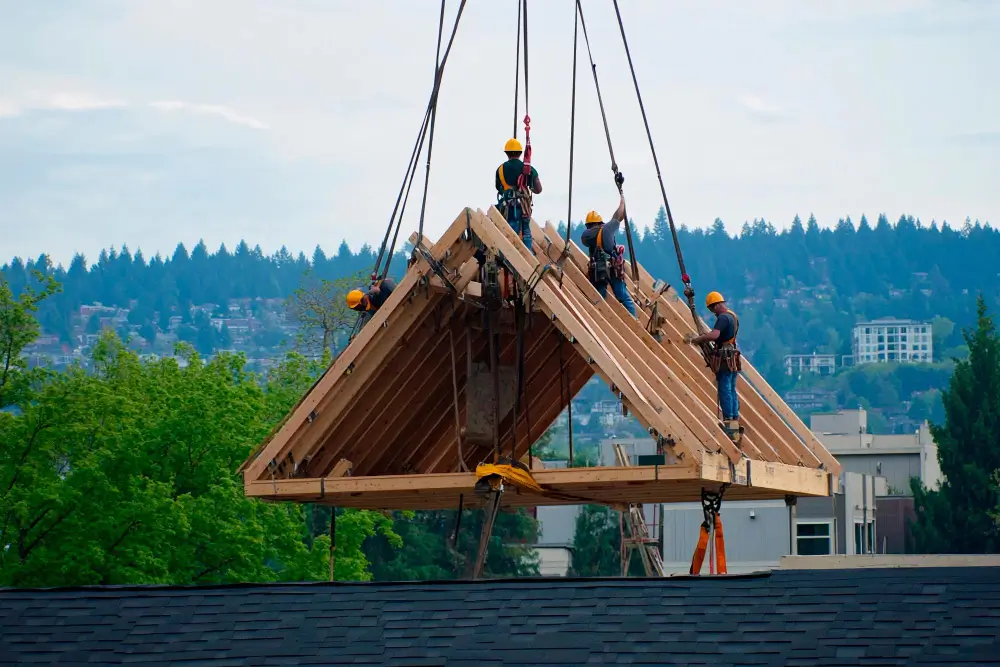 House roof structure installation in progress with labor and crane support
